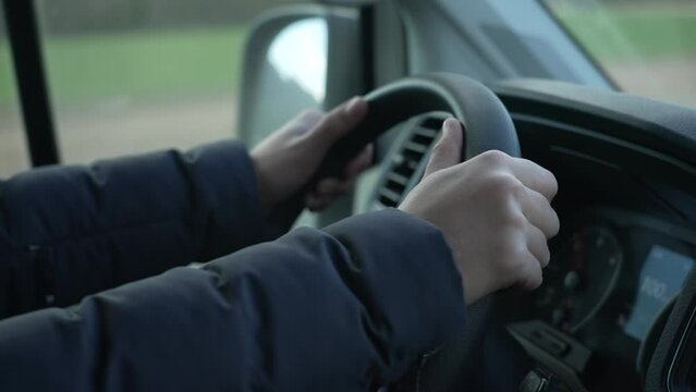 Close-up hand holding truck steering wheel driving on road