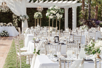 wedding arch for an outdoor wedding ceremony on a green lawn, decorated with white flowers