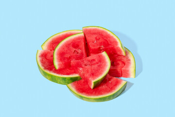 Pieces of sliced delicious juicy watermelon on a light blue background, summer dessert