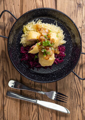 dumpllings filled with smoked meat served with red and white cabbage