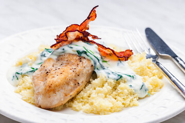 poultry breast with spinach creamy sauce and bacon served with couscous