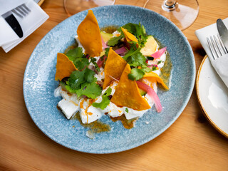 Salad with soft cheese burrata, ripe avocado, fresh aromatic greens and corn tortilla chips....