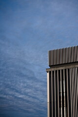 Krawędź nowoczesnego budynku ze stali na tle błękitnego nieba w słoneczny dzień 