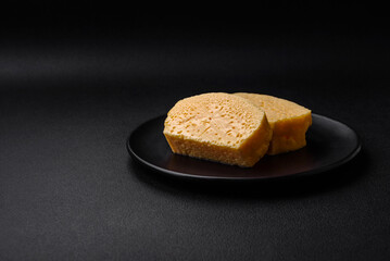 Delicious porous yellow cheese cut in large pieces on a ceramic plate