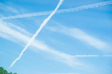 Art works of beautiful clouds over blue sky. Lines or cloud condensation traces arc across the sky. These sky art lines occur when aircraft exhaust condenses and clouds freeze. Ideal for designer 