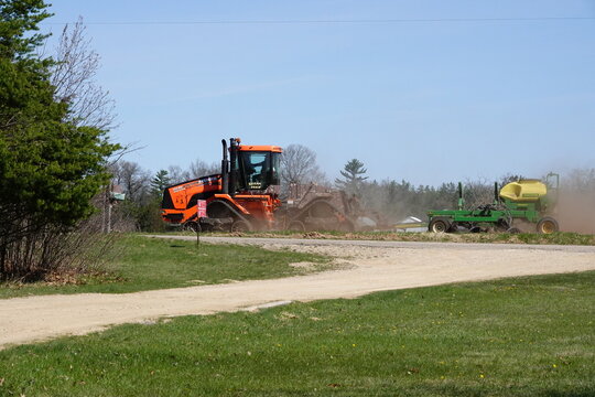 Orange Case IH Steiger 380 DS Quadtrac tractor farming the crop field.