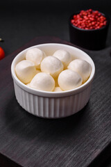 Delicious fresh mozzarella cheese in the form of small balls with salt and spices