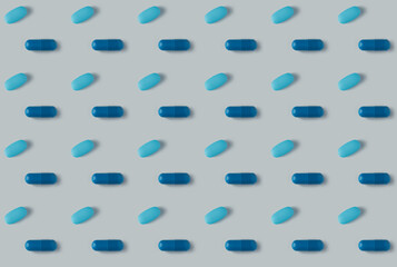 pattern of pills on a blue background. Many pills on a light background