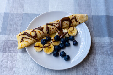 Traditional Ukrainian pancakes with bananas, chocolate and blueberry