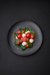 Foto op Plexiglas Delicious fresh salad with mozzarella cheese, cherry tomatoes, herbs, salt and spices © chernikovatv