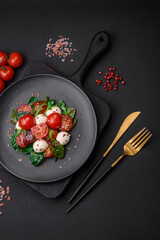 Delicious fresh salad with mozzarella cheese, cherry tomatoes, herbs, salt and spices