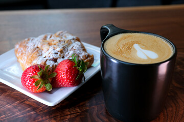 close-up of french breakfast with croissants in white plate, coffee, orange juice and omelet in background. Cappuchino and croissant in the cafe