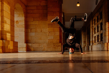 teenager boy dancing breakdance on a tiled floor in the street. youth culture and hip-hop culture