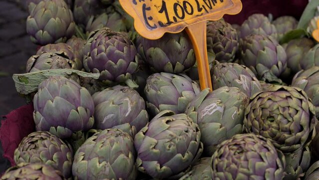 Organic green artichoke at the retail farmer's market of fresh vegetables and fruits.