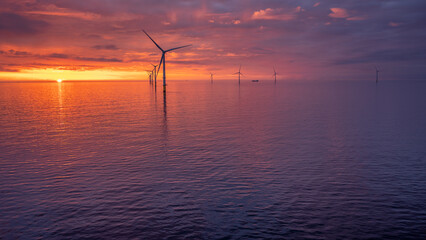 Sunset offshore at wind turbine farm