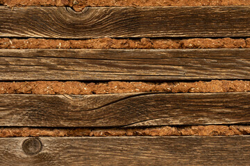Wood, straw and soil background. The wall of the barn. Unusual background with space for signature.
