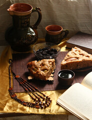 Homemade apple pie, tea, wooden necklace and jam from cones on the table.
