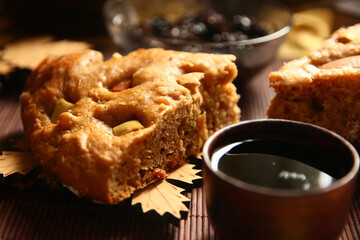 Homemade apple pie, tea, wooden necklace and jam from cones on the table.