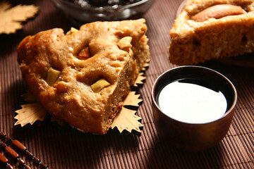 Homemade apple pie, tea, wooden necklace and jam from cones on the table.