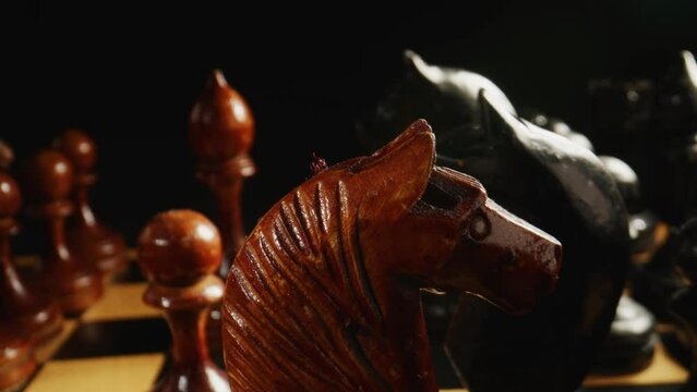 Close-up of chess on a black background. Wooden chess pieces. Concept: the Board game and the intellectual activities.