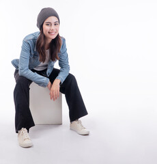 Cheerful asian university student girl wear denim jacket holding hands sitting on white chair  over...