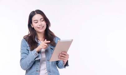 Fototapeta premium Cheerful asian woman denim jacket holding tablet thinking creative idea standing over isolated white background. Student young girl pointing finger touch screen education tablet. Lifestyle technology.