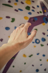 hand reaching out to a climbing wall
