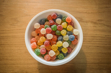 bowl with gummies on wooden background