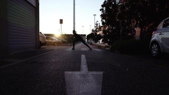 Dancer silhouette performs on zebra crossing at sunset