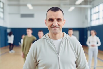 Fototapeta premium Portrait of senior man in sportswear standing in front of group of people in dance studio