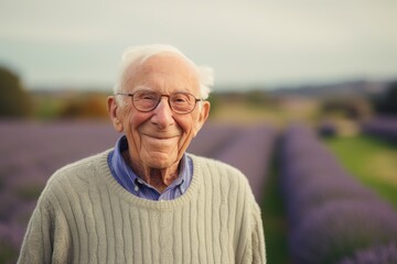 Portrait of senior man standing in lavender field smiling at camera