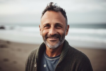 Portrait of handsome middle-aged man smiling at camera on the beach