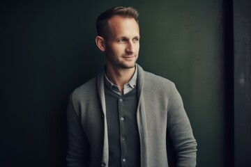 Obraz premium Portrait of a handsome young man in a gray jacket on a dark background