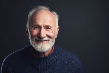 Obraz premium Portrait of a smiling senior man in sweater on black background.