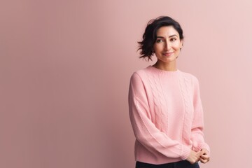 Obraz premium Portrait of a beautiful young woman standing against a pink background.