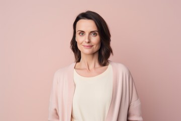 Fototapeta premium Environmental portrait photography of a satisfied woman in her 30s wearing a chic cardigan against a pastel or soft colors background. Generative AI