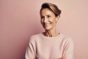 Fototapeta premium Portrait of a beautiful middle-aged woman on a pink background