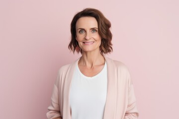 Obraz premium Portrait of smiling mature woman looking at camera isolated on pink background