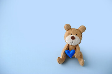 urso segurando coração azul, feliz dia dos pais, espaço para texto em fundo azul