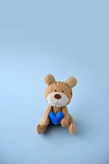 urso segurando coração azul, feliz dia dos pais, espaço para texto em fundo azul