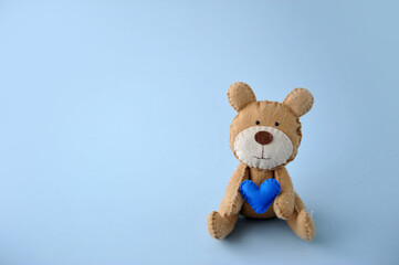 urso segurando coração azul, feliz dia dos pais, espaço para texto em fundo azul