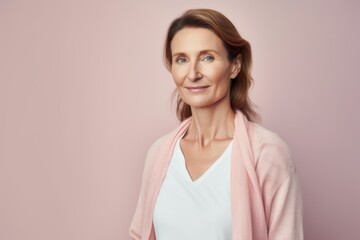 Obraz premium Portrait of a beautiful mature woman in a pink sweater on a pink background