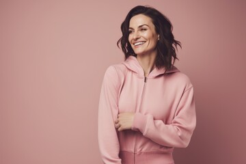 Fototapeta premium Portrait of happy woman in pink hoodie on pink background.