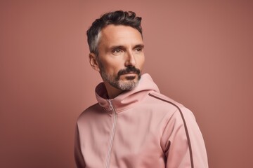 Fototapeta premium Portrait of a handsome middle-aged man in a pink hoodie.