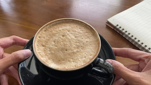 shaking and jiggle coffee foam on black cup. cute and delicious coffee foam