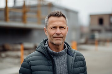 Portrait of a middle-aged man in a jacket on a construction site