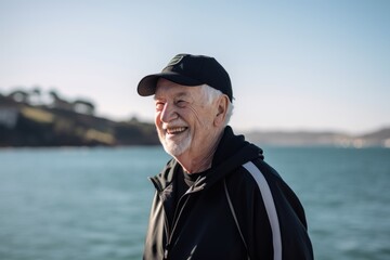 Obraz premium Portrait of a senior man standing by the sea and smiling.