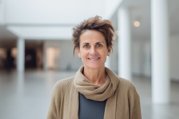 Portrait of smiling mature woman standing in corridor of modern office building
