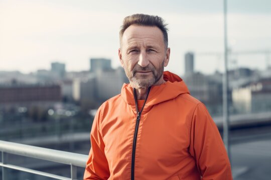 Handsome middle-aged man in sportswear looking at camera while standing outdoors