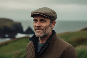 Medium shot portrait photography of a pleased man in his 40s wearing a cool cap or hat against a windswept or dramatic landscape background. Generative AI